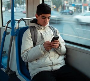 Moroccan student using a smartphone on a tram in Casablanca